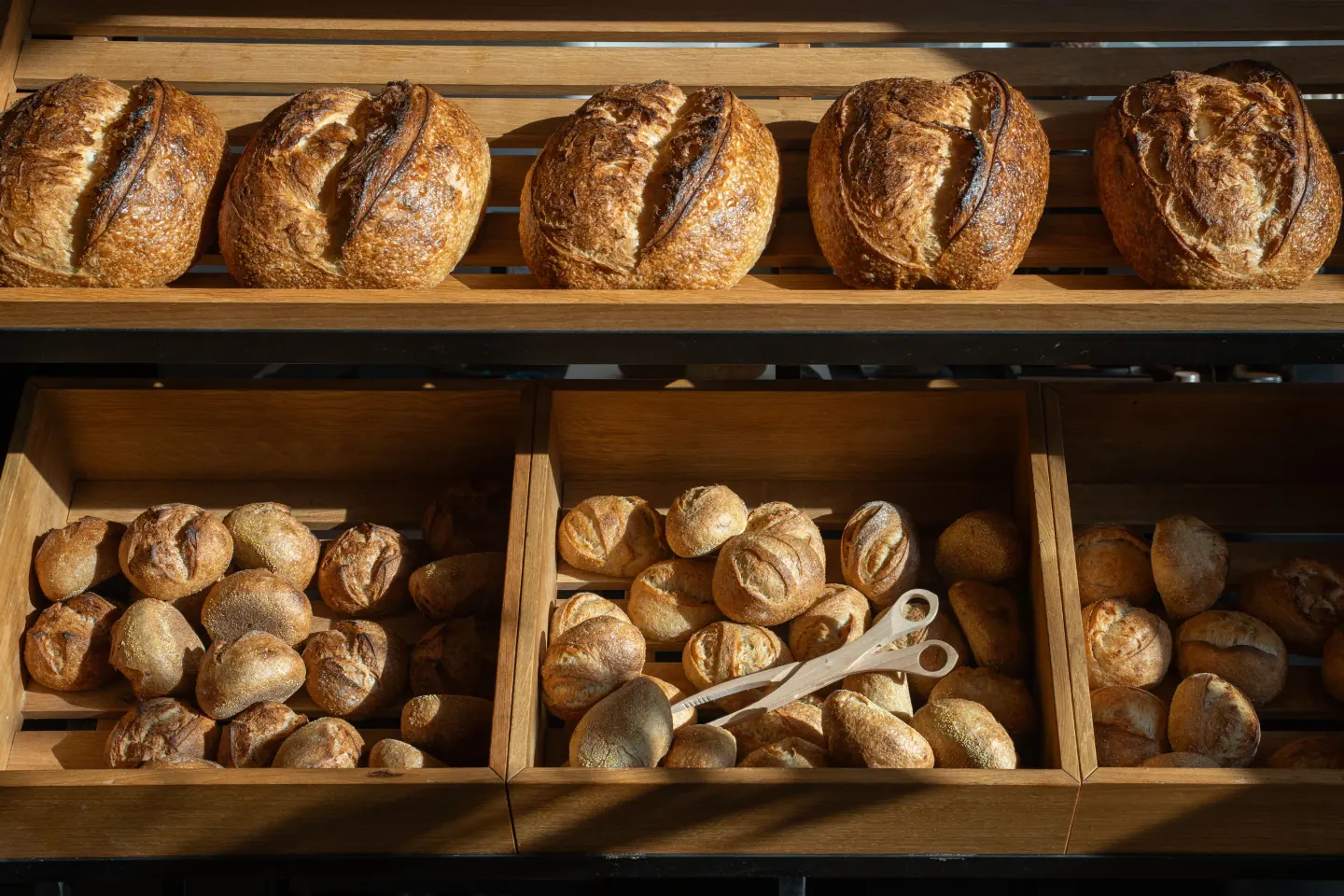 Broodwand met desembroden op de plank en bollen in houten bakken