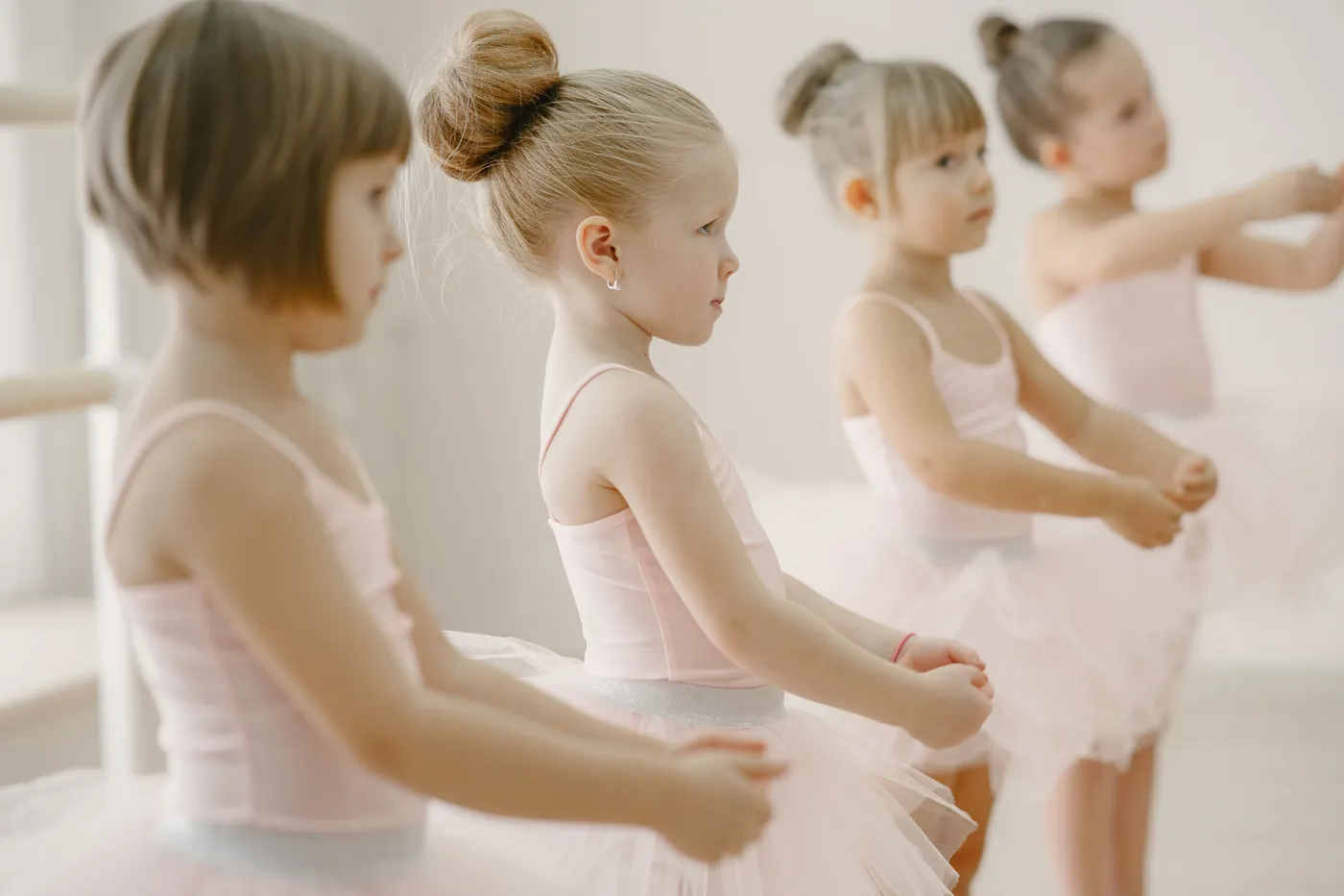 Kleuters in roze balletpakjes oefenen aan de barre