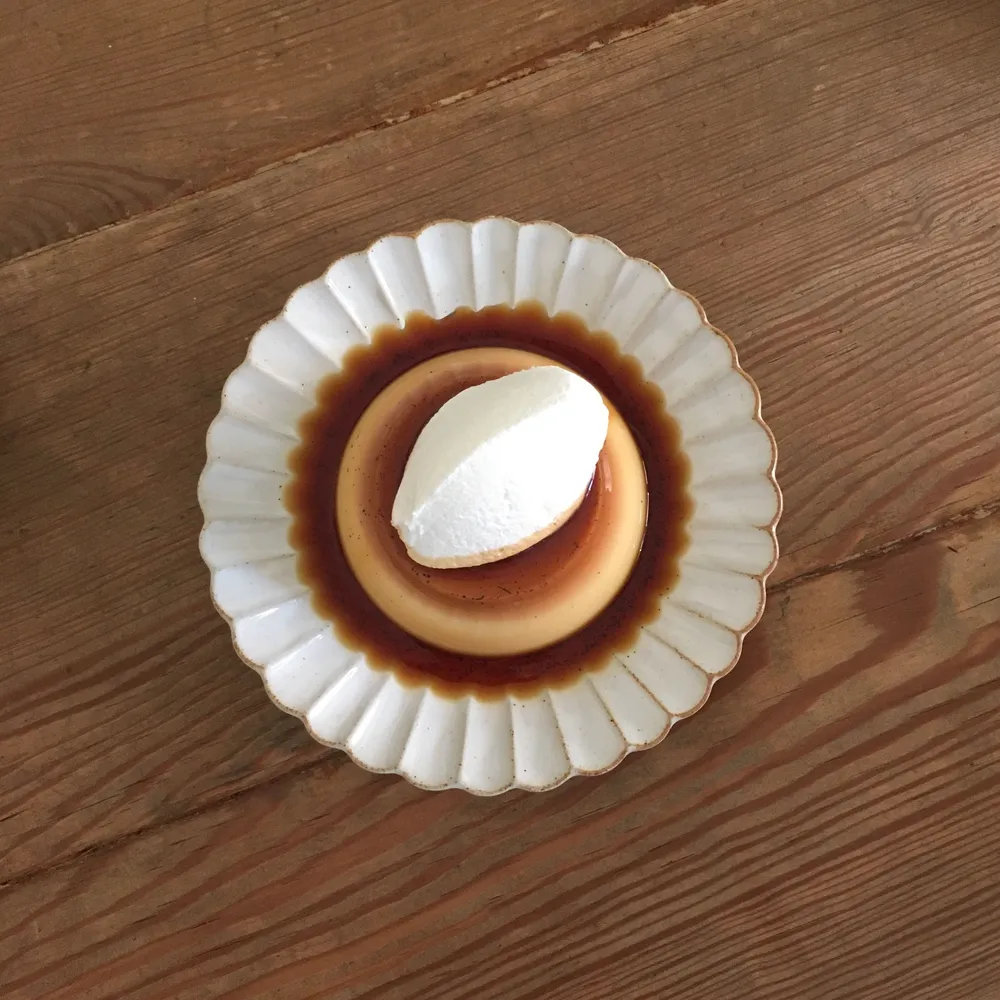 Karamelpudding met room op een geschulpt bord
