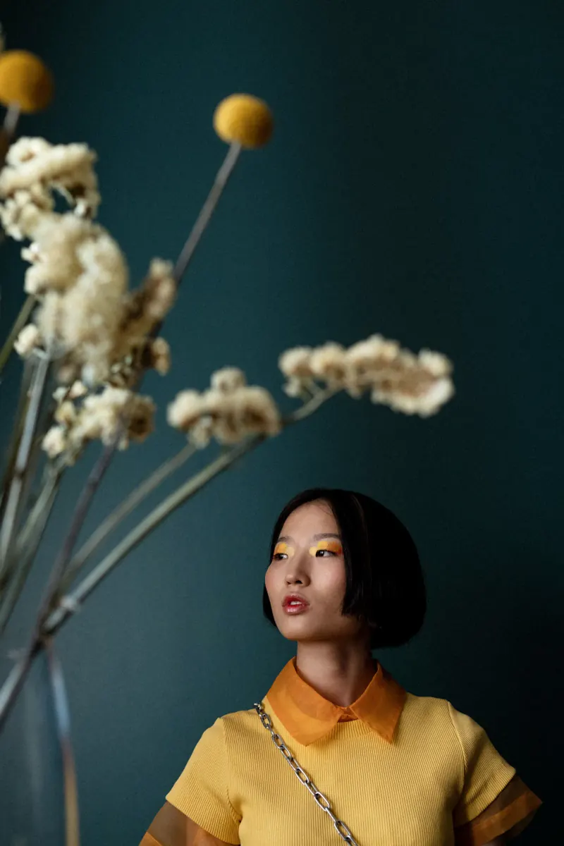 Kapper met een bob voor een groene muur, gedroogde bloemen op de voorgrond