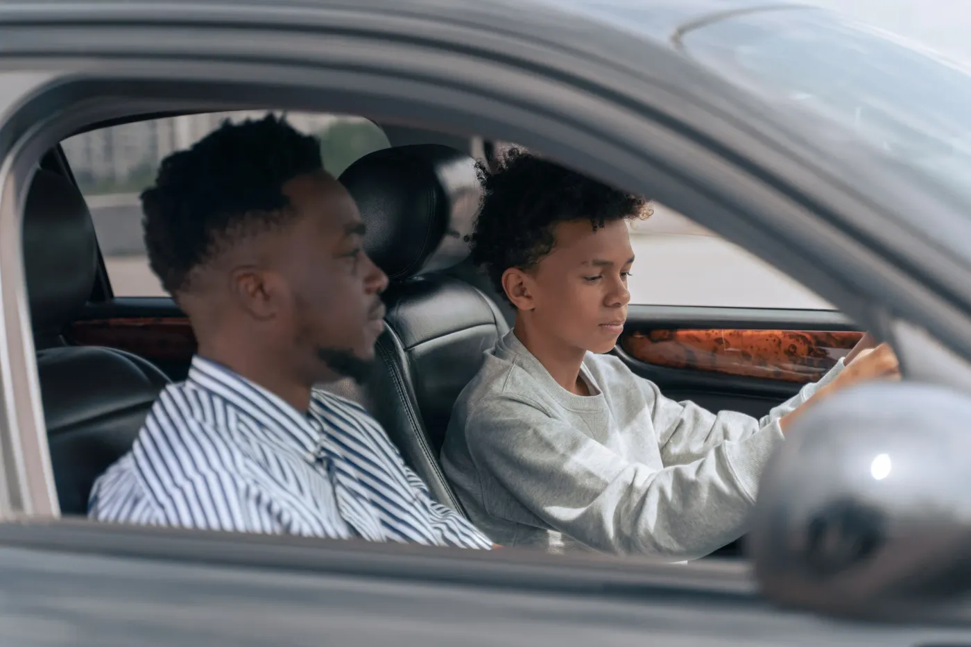 Een instructeur en een leerling in de auto, gezien door het zijraam