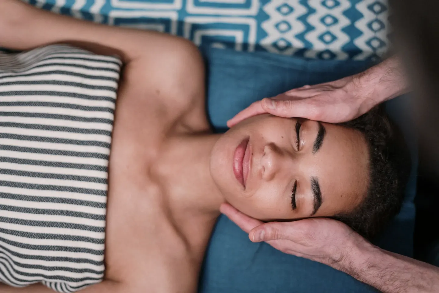 Een gezichtsmassage in een donkere behandelkamer met kaarsen