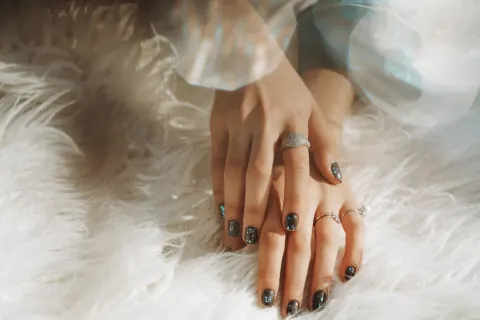 Donkergrijze nagels met ringen op wit bont