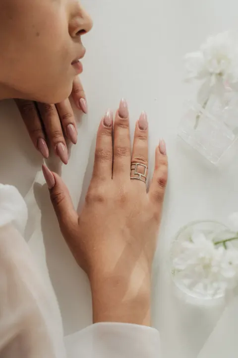 Nude amandelnagels met een gouden ring