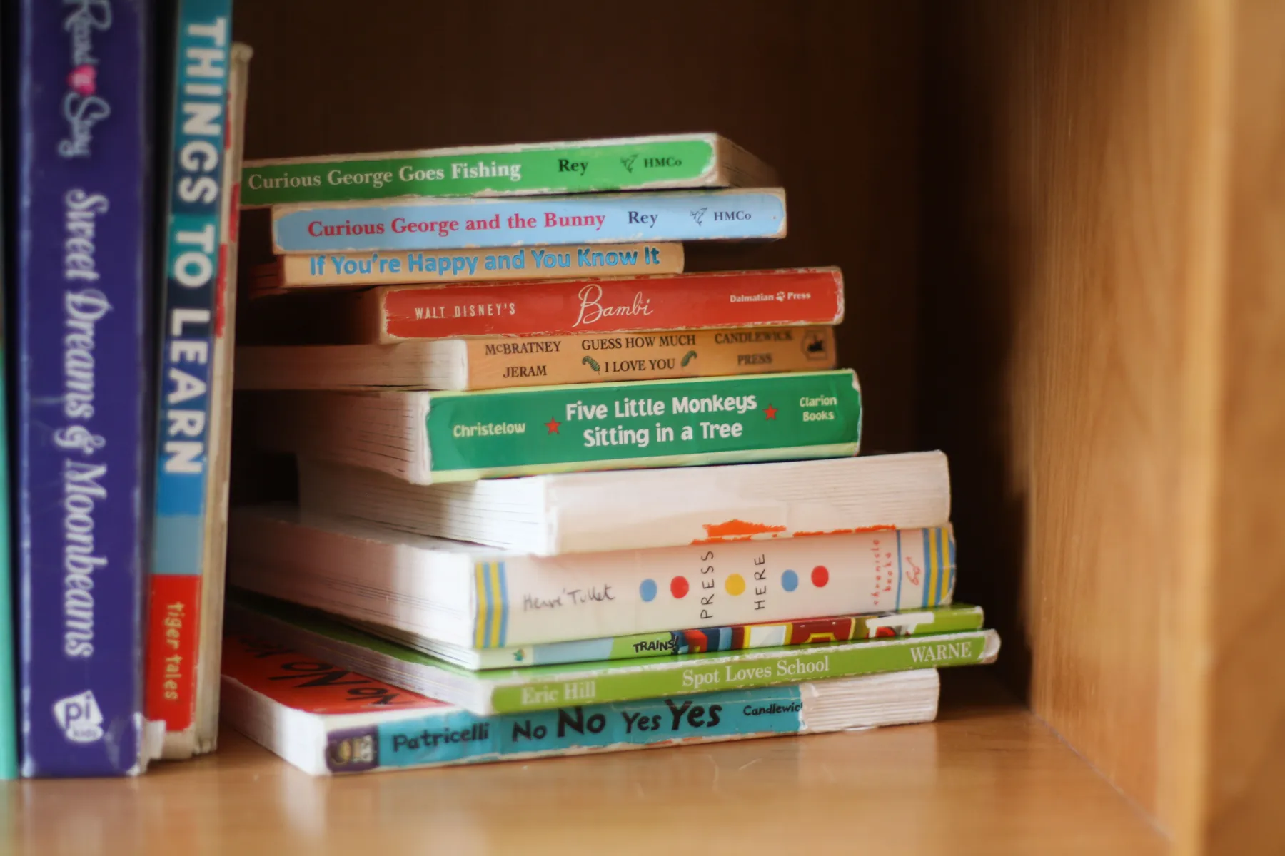 Een stapel prentenboeken op een houten plank
