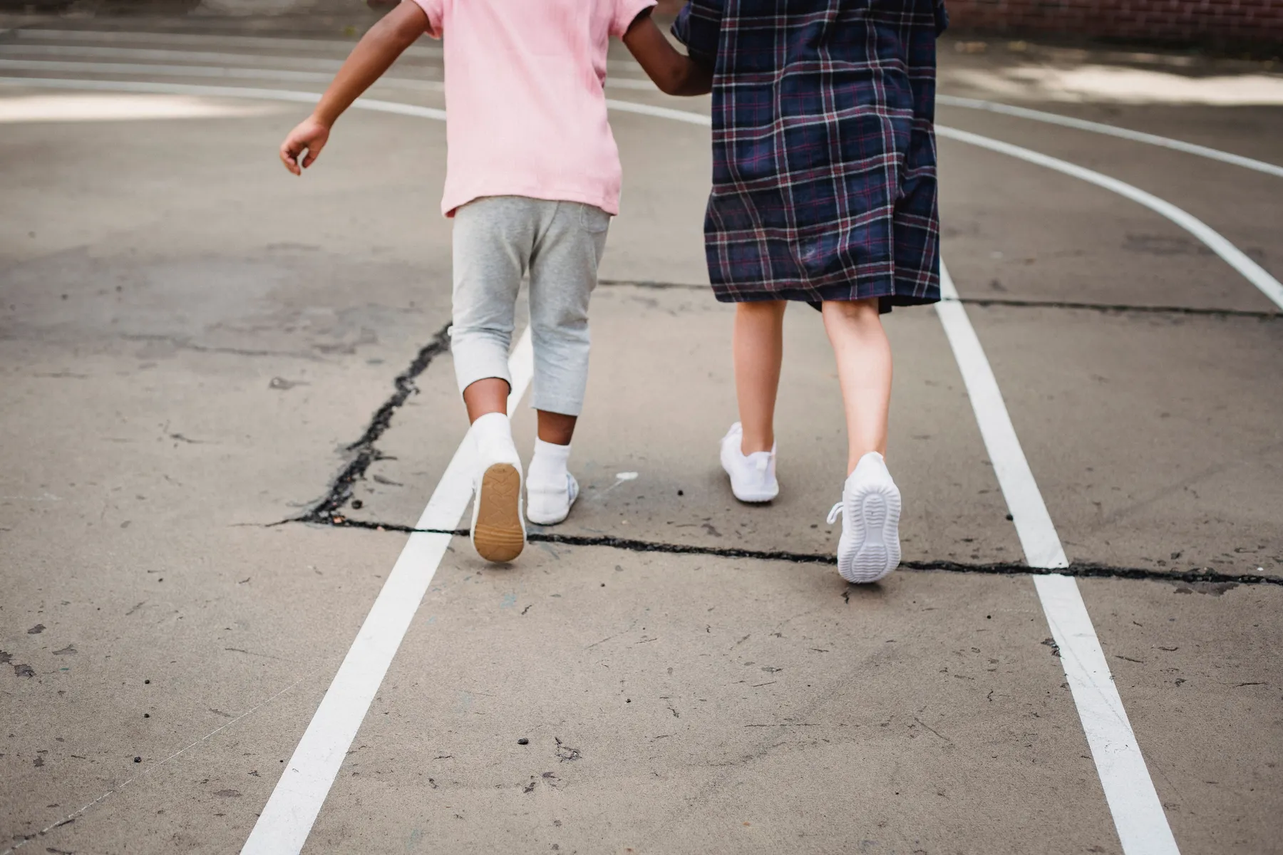 Kinderen in witte schoenen lopen over het schoolplein
