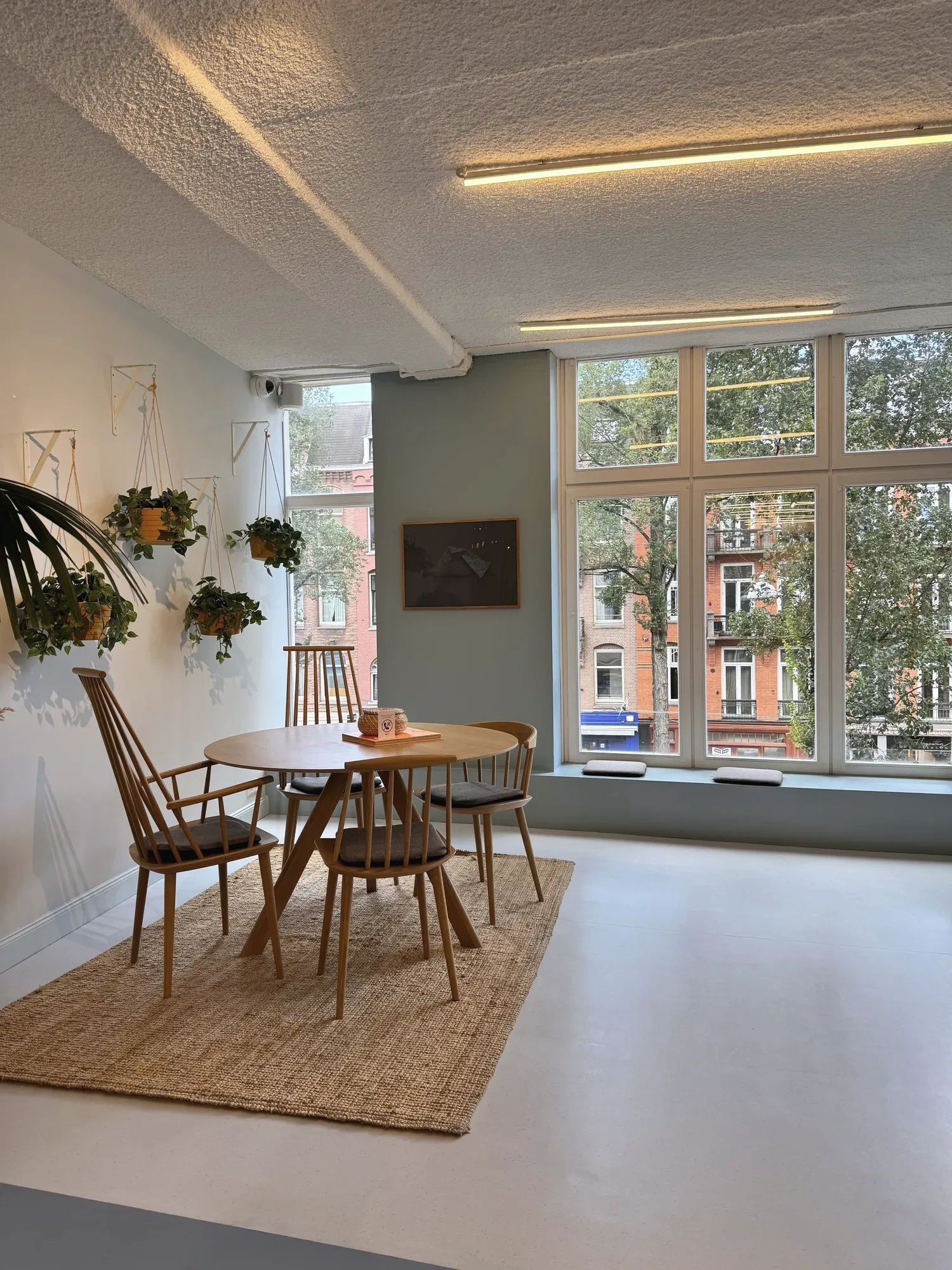 Een lichte eethoek met een ronde tafel bij grote ramen