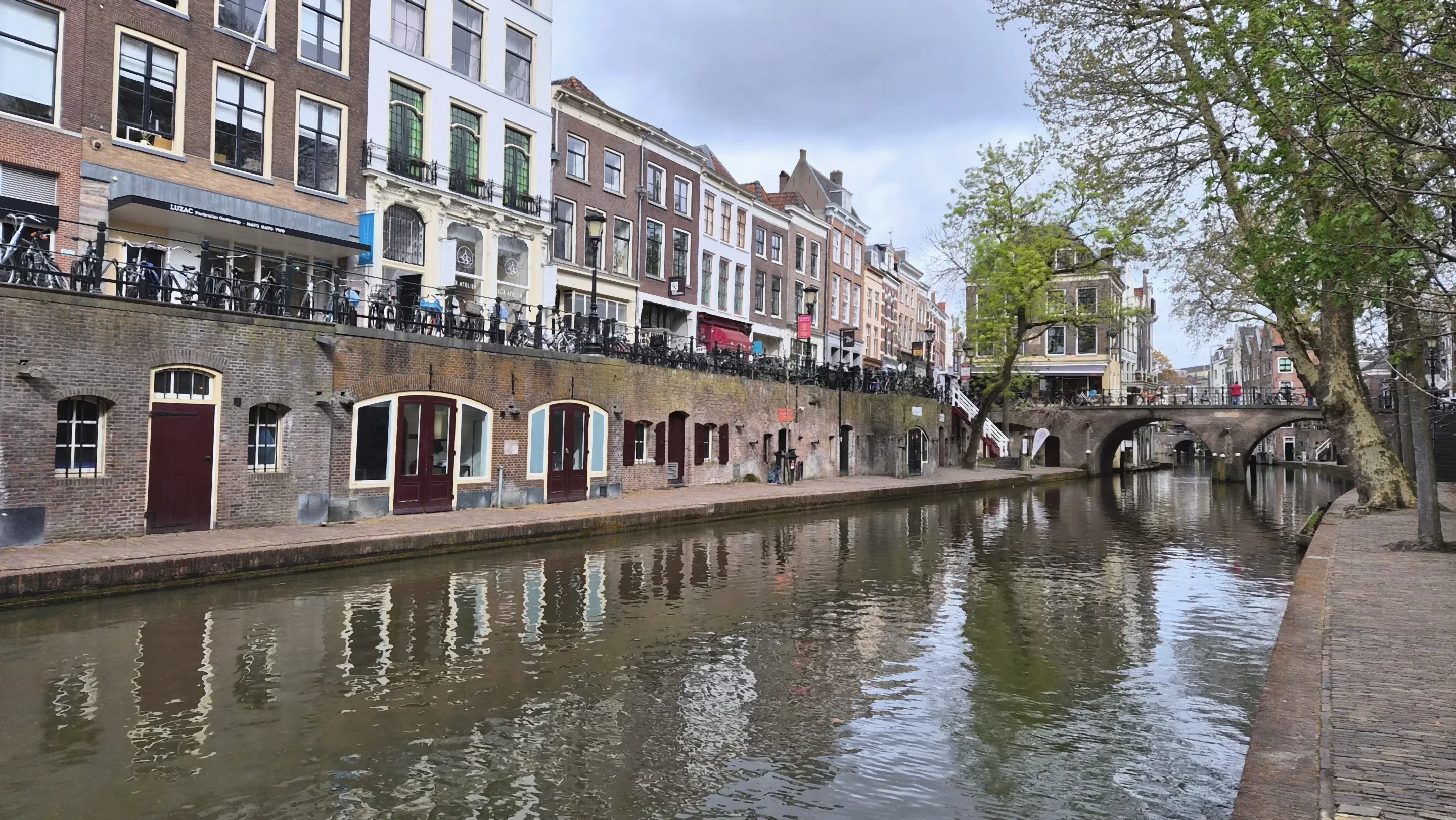 De Oudegracht in Utrecht met werfkelders, bomen en een brug